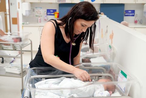 דר. שפורן בודקת תינוקות בזמן המלחמה, שעות ספורות אחרי שהיא עצמה ילדה את בנה. אלבום פרטי